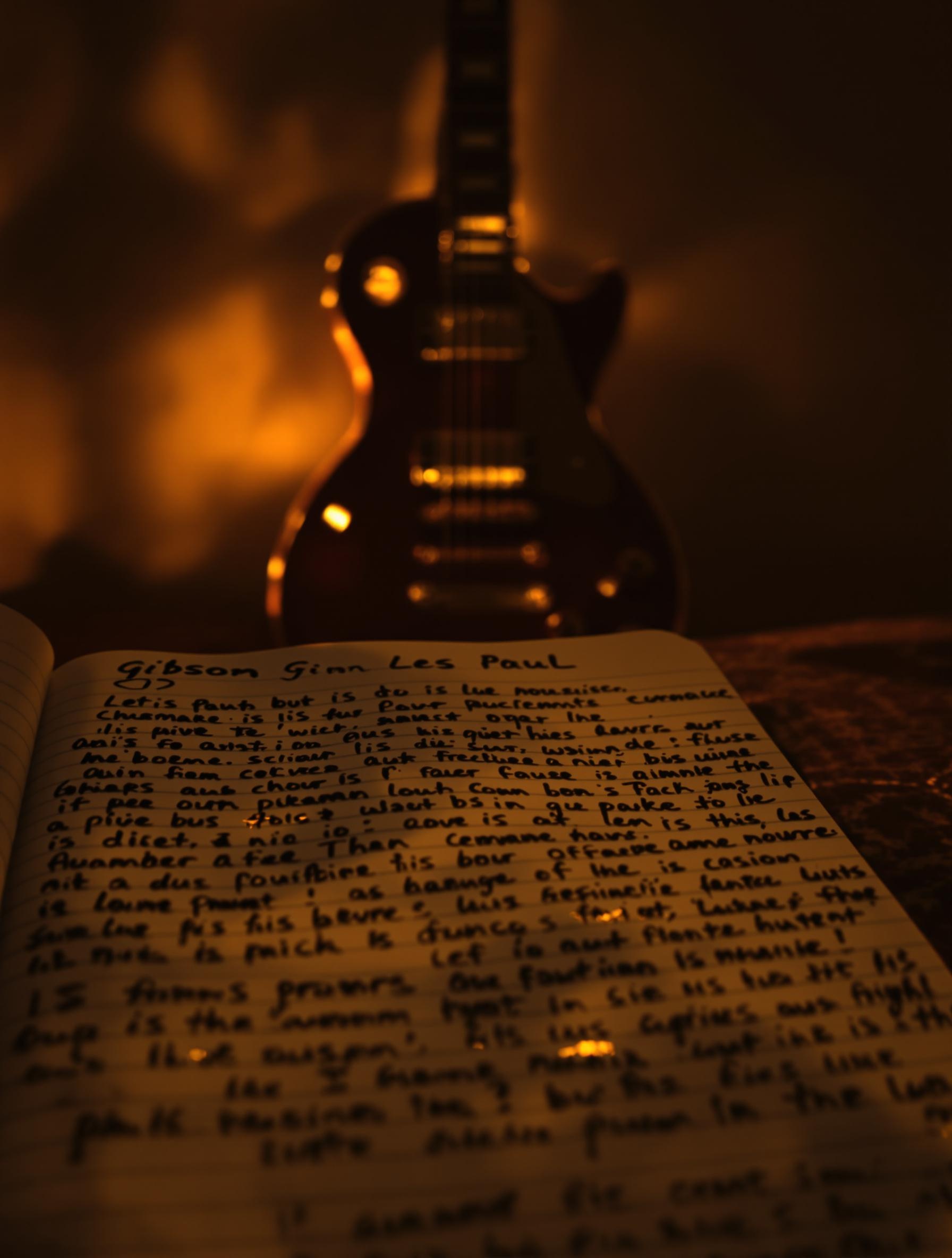 Carnet usé avec annotations lyriques et guitare Gibson Les Paul