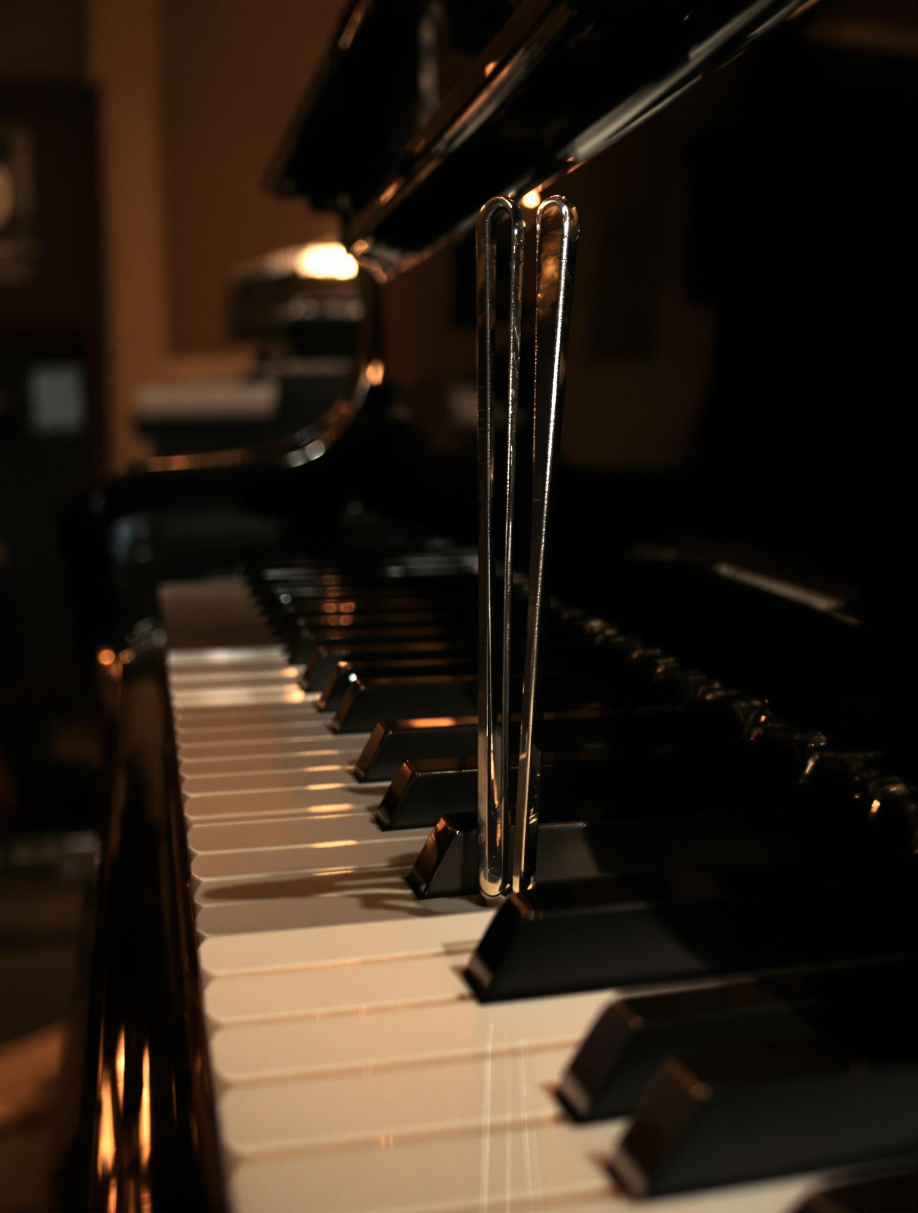Diapason en acier vibrant à 440 Hz, prêt à donner le La dans l’éclairage tamisé d’un studio analogique.