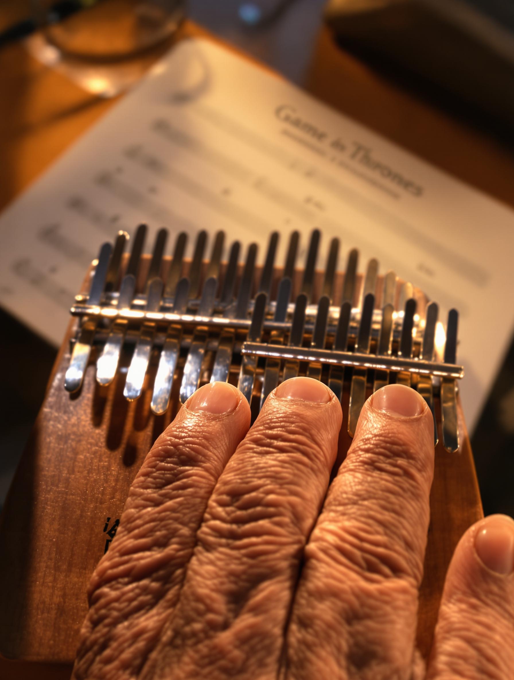 Fin de session kalimba Game of Thrones avec partition et main sur piano à doigts.