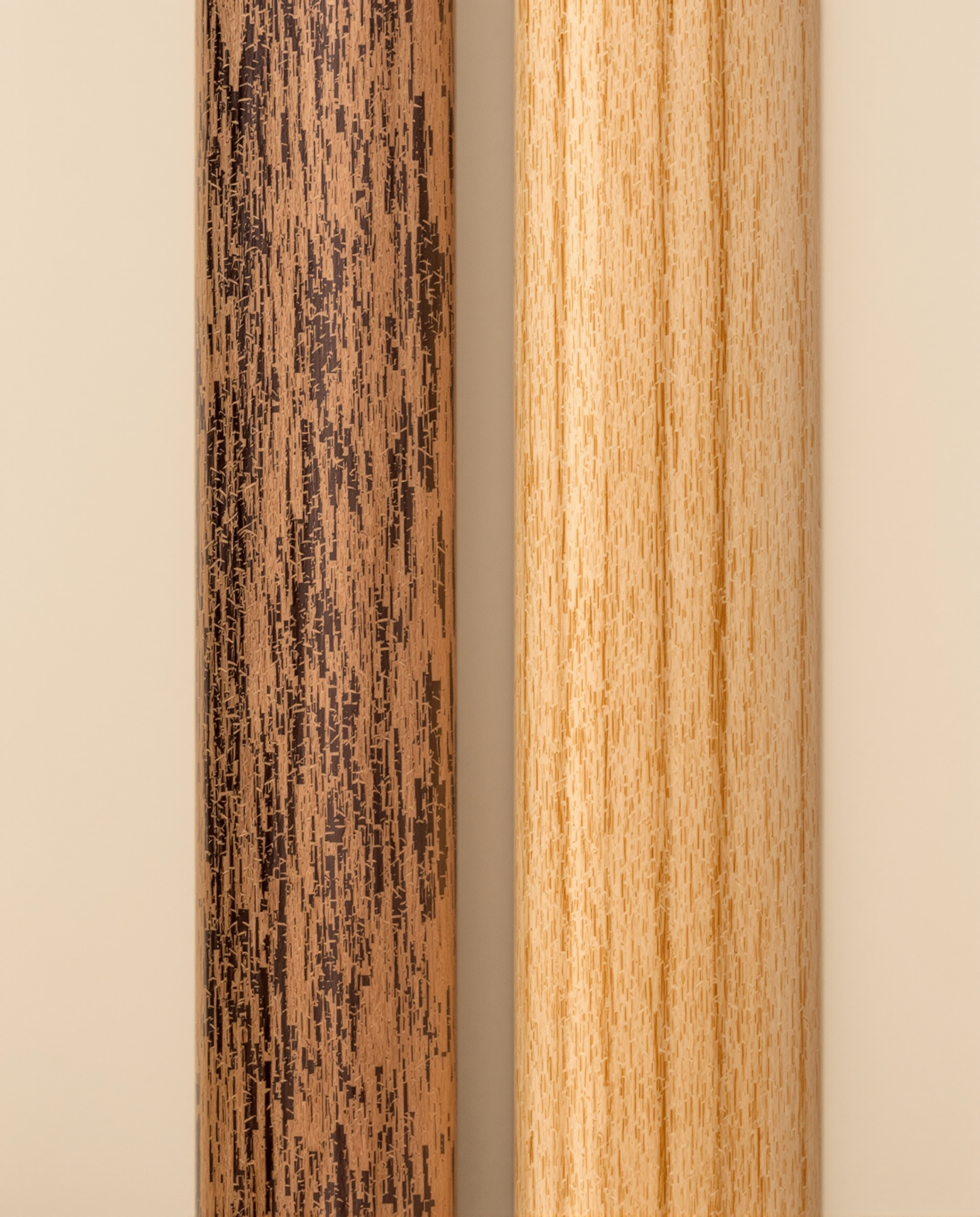 Gros plan sur la texture et le grain de deux paires de baguettes 7A, l'une en Hickory avec sa teinte plus sombre et son grain prononcé, l'autre en Érable (Maple), plus clair et fin, illustrant l'âme du bois qui définit le son.