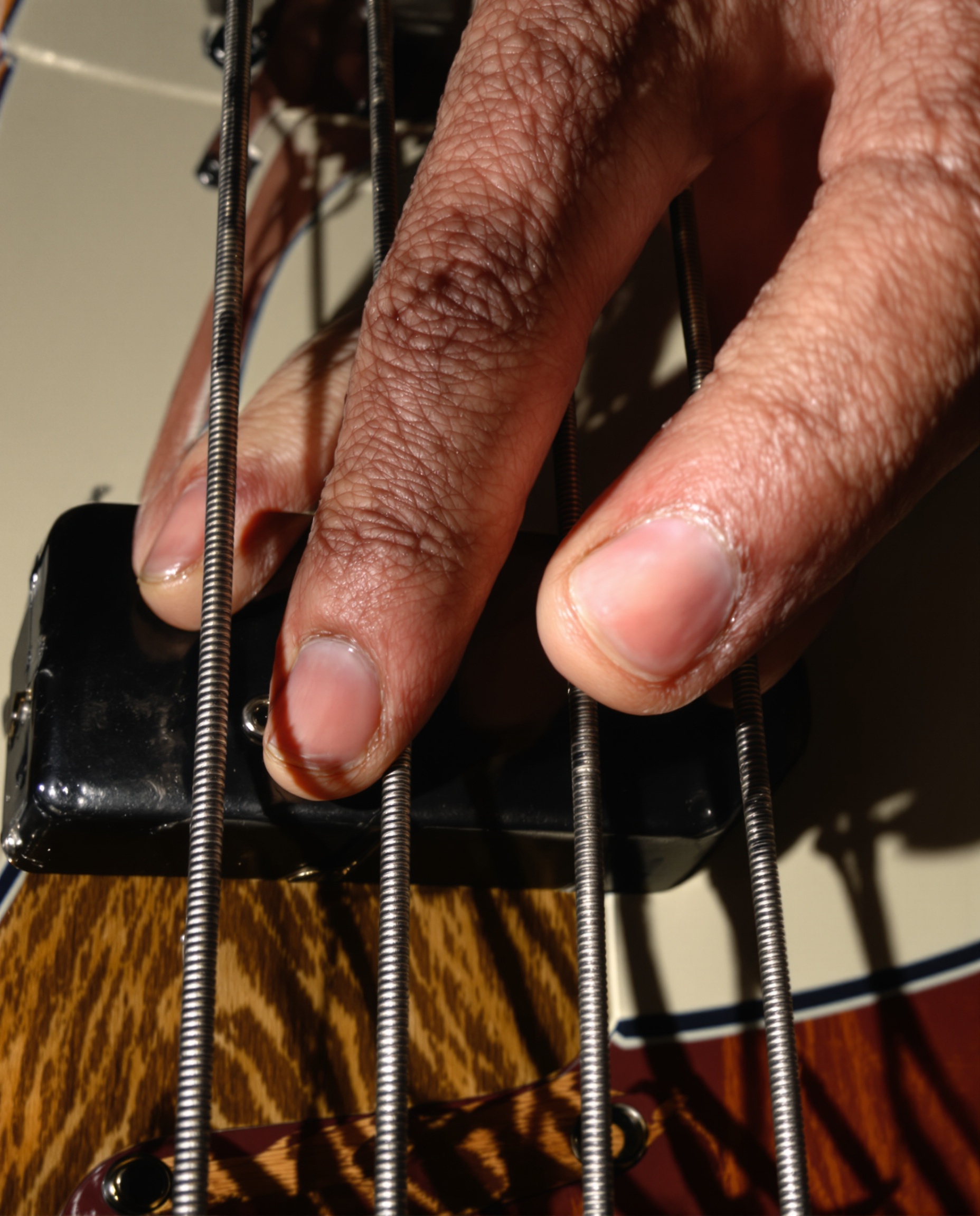 Gros plan main droite bassiste jouant aux doigts Fender Precision Bass