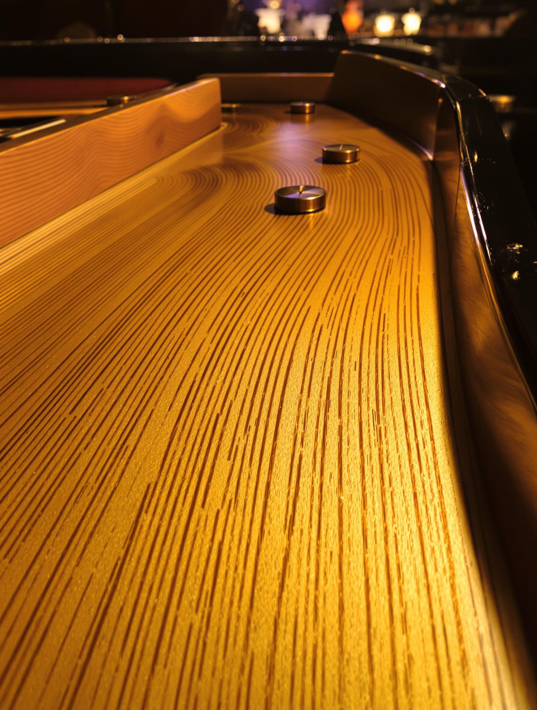 Gros plan sur la table d’harmonie en épicéa sélectionné, texture naturelle et fibres vibrantes.