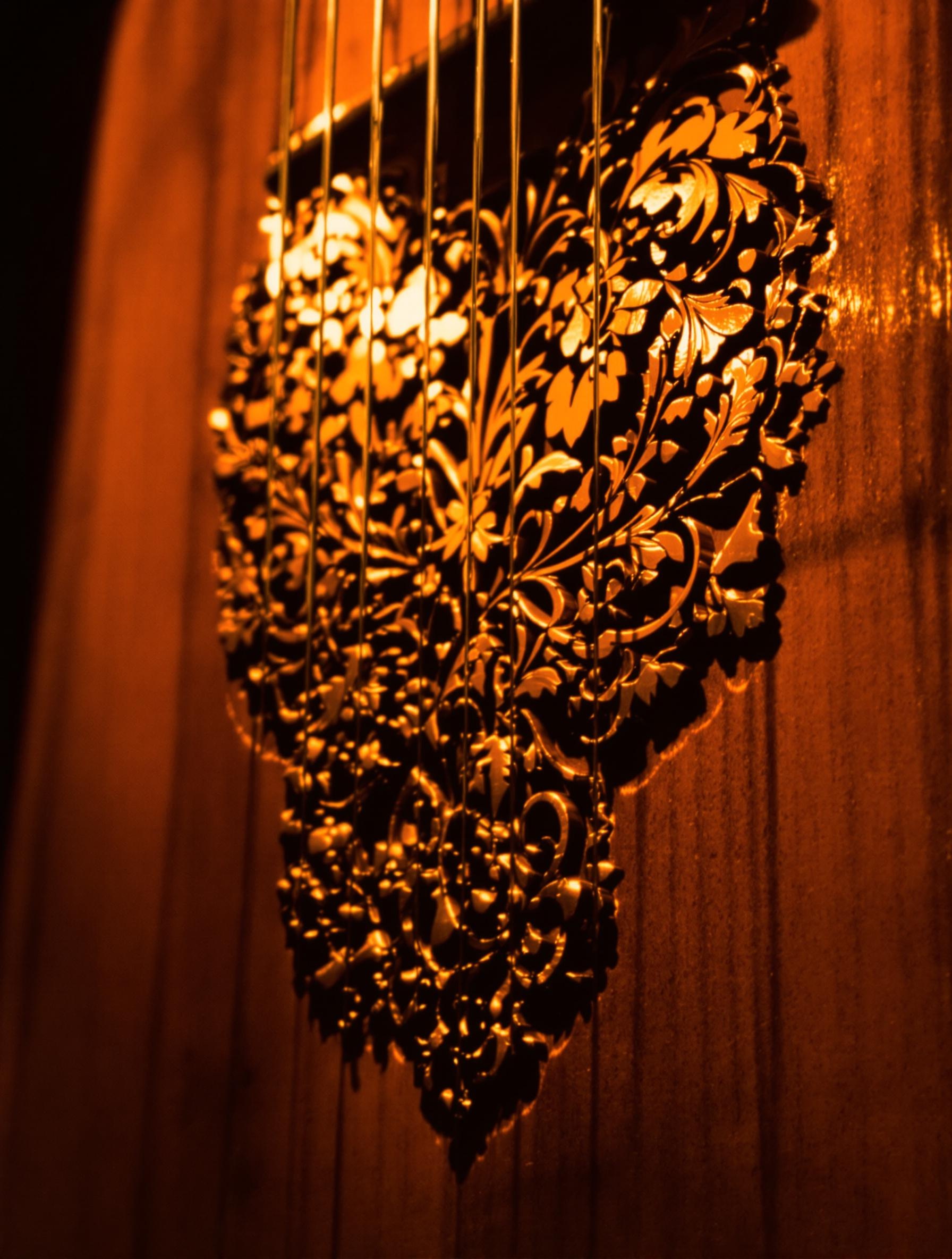 Gros plan sur la tapa entaillée d’un cajón flamenco poli, grains visibles sous une lumière chaude rappelant le tablao sévillan.