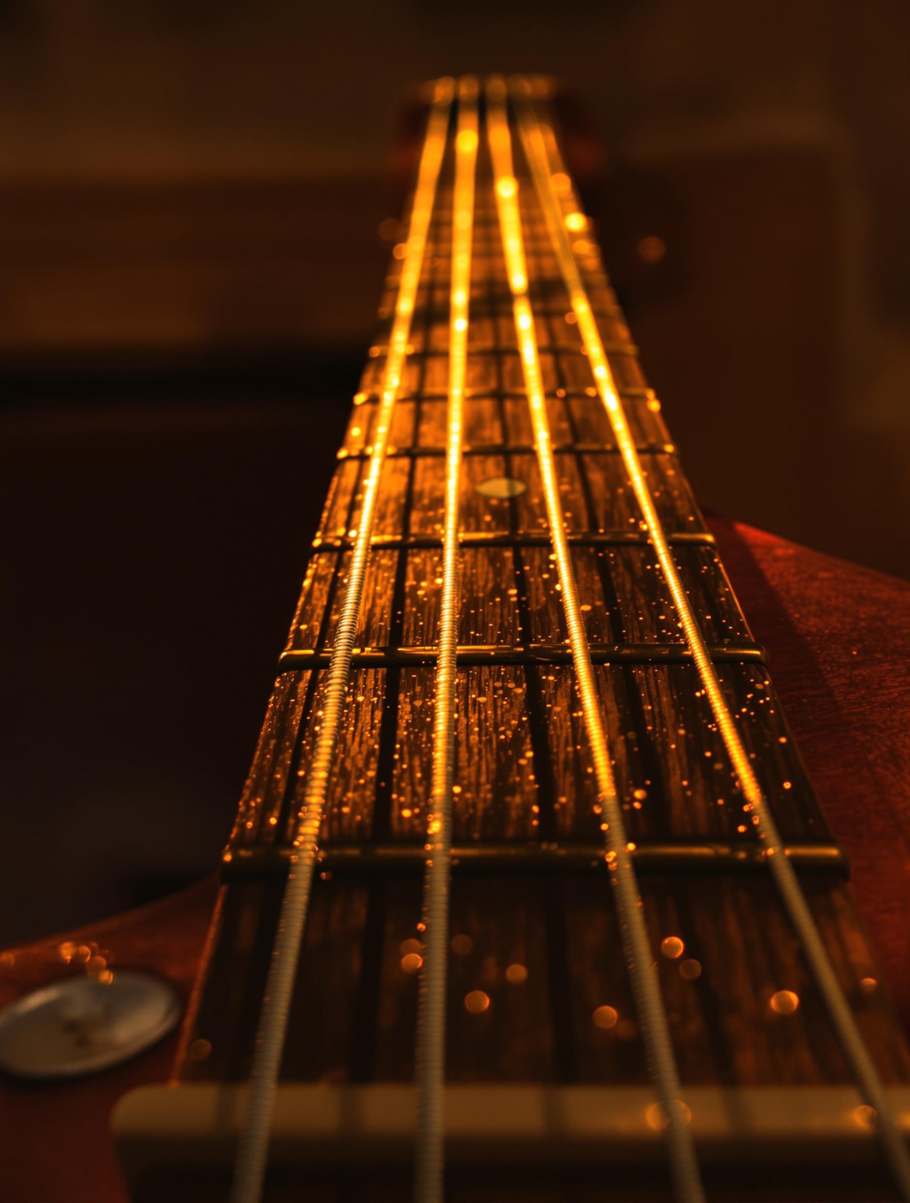 Gros plan sur une guitare espagnole, lumière dorée et doigts prêts à frapper les cordes – entre tradition et innovation.