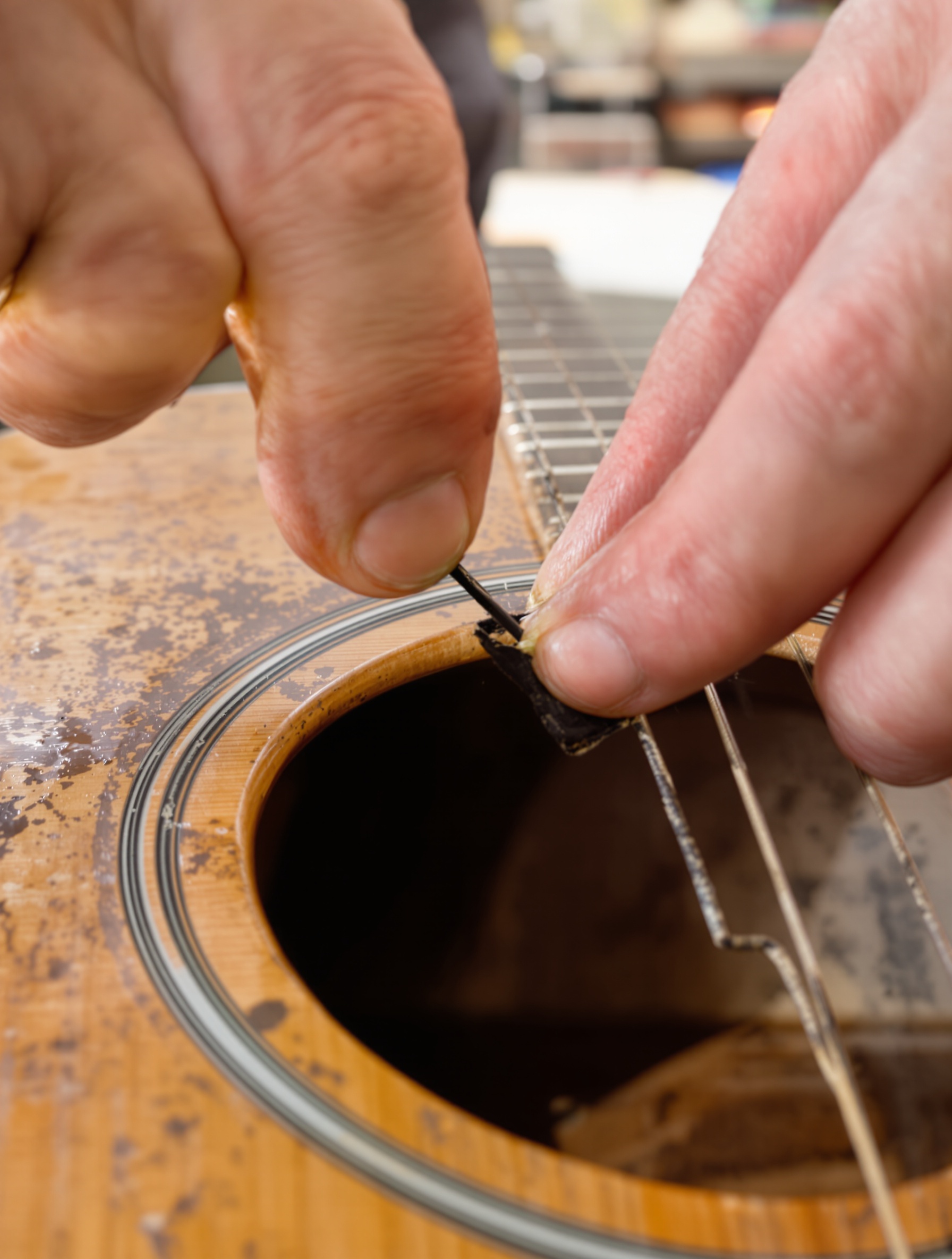 Gros plan main retirant vieille corde oxydée guitare acoustique