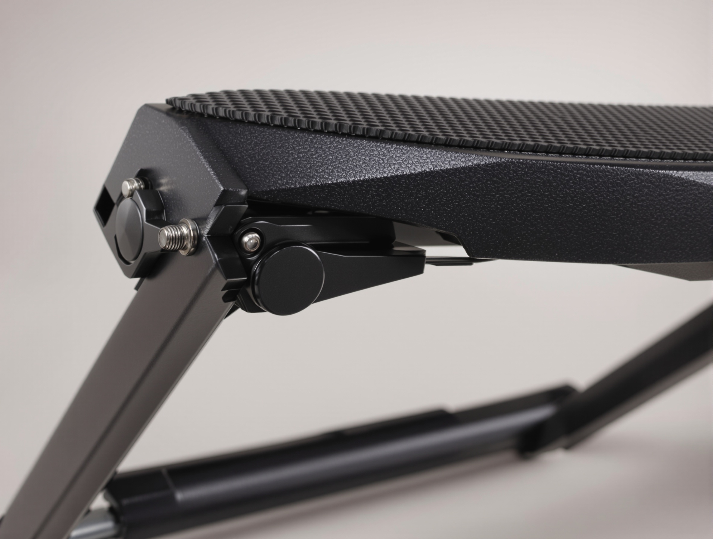 Gros plan sur un repose-pied guitare métallique pliable montrant les crans de réglage et le patin antidérapant.