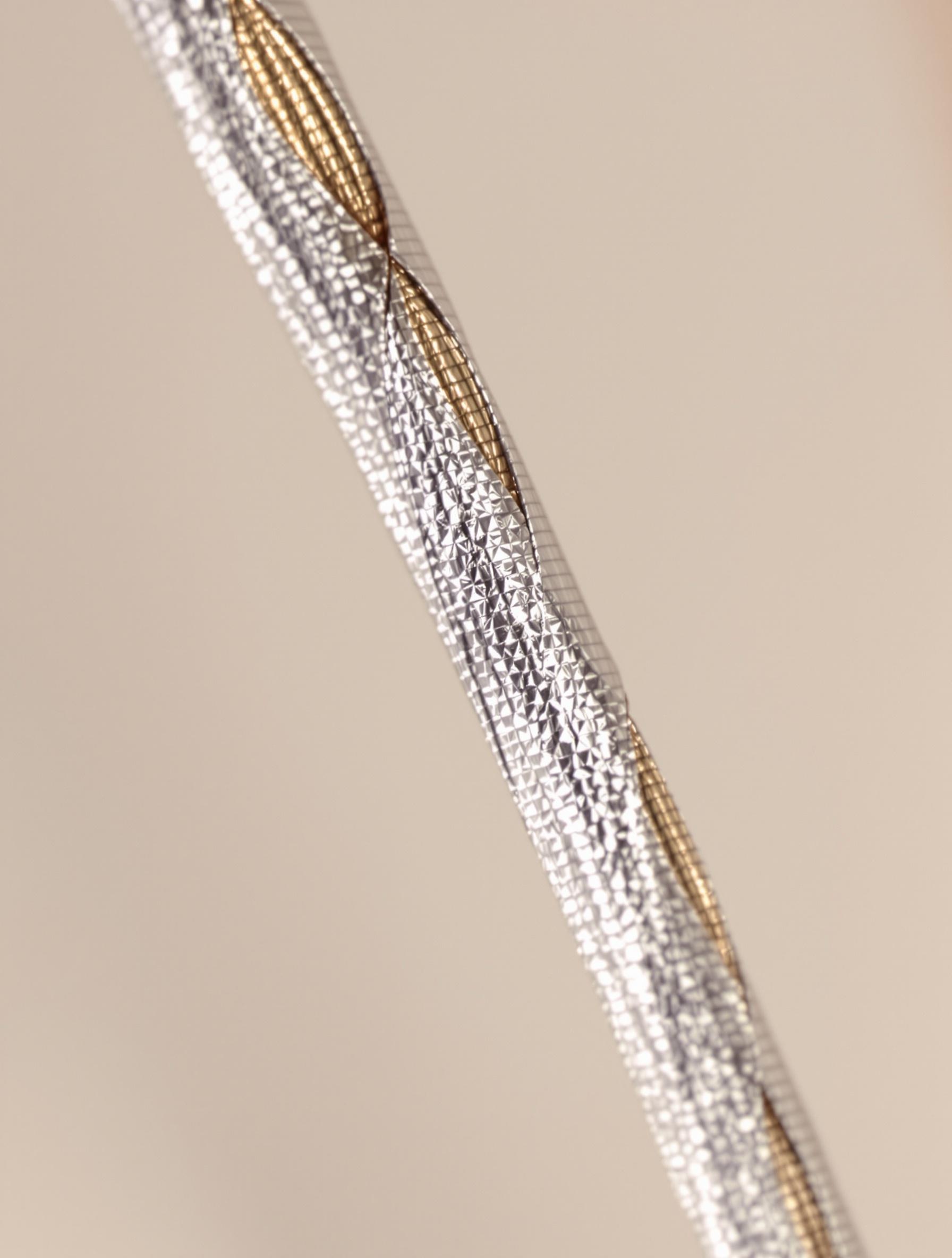 Détail zoomé sur une corde filée de guitare classique, montrant le noyau en nylon et le fil d'enroulement en cuivre argenté.